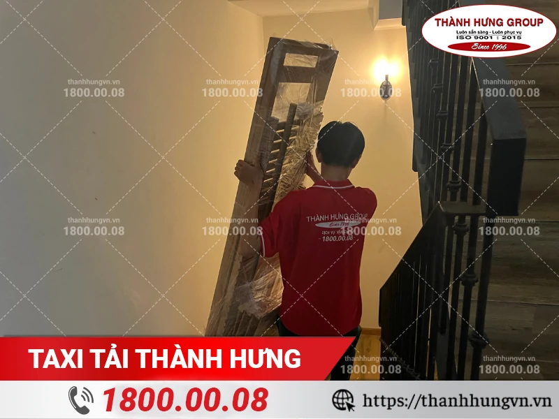Nhân viên Thành Hưng vận chuyển đồ cồng kềnh qua cầu thang hẹp