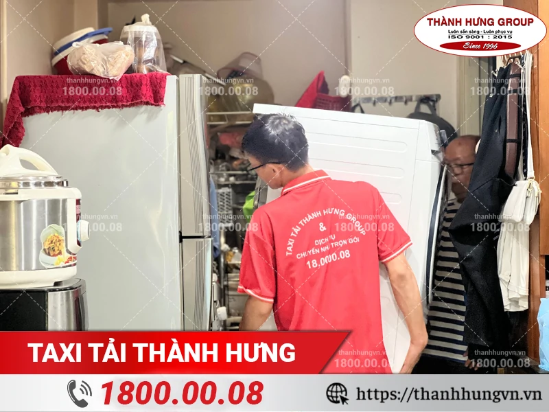 Nhân viên Thành Hưng đang khuân vác máy giặt ra xe tải vận chuyển