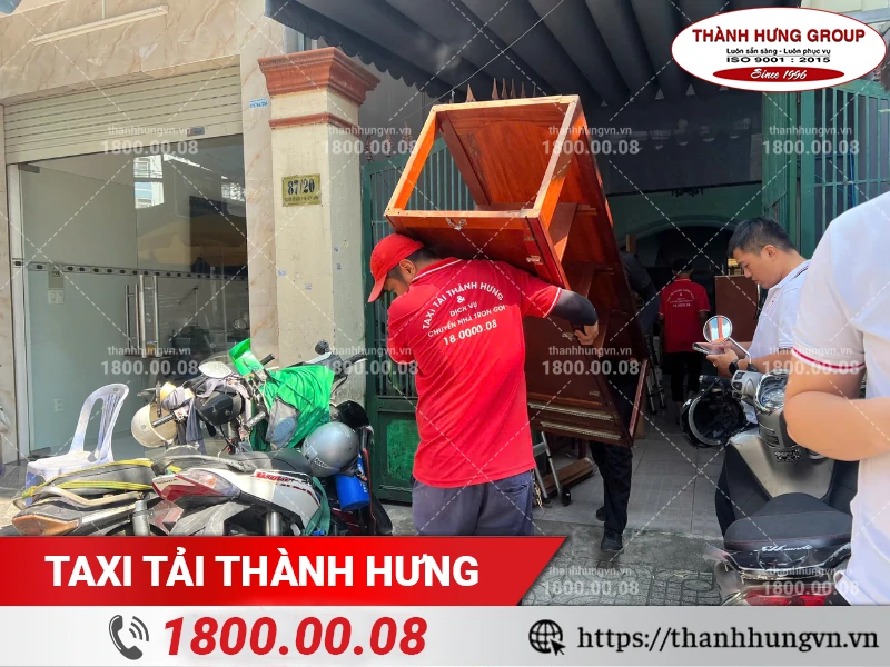 Nhân viên Thành Hưng vận chuyển tủ gỗ từ trong nhà ra xe