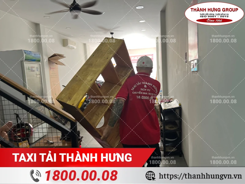 Nhân viên Thành Hưng khuân vác kệ gỗ qua đường thang bộ