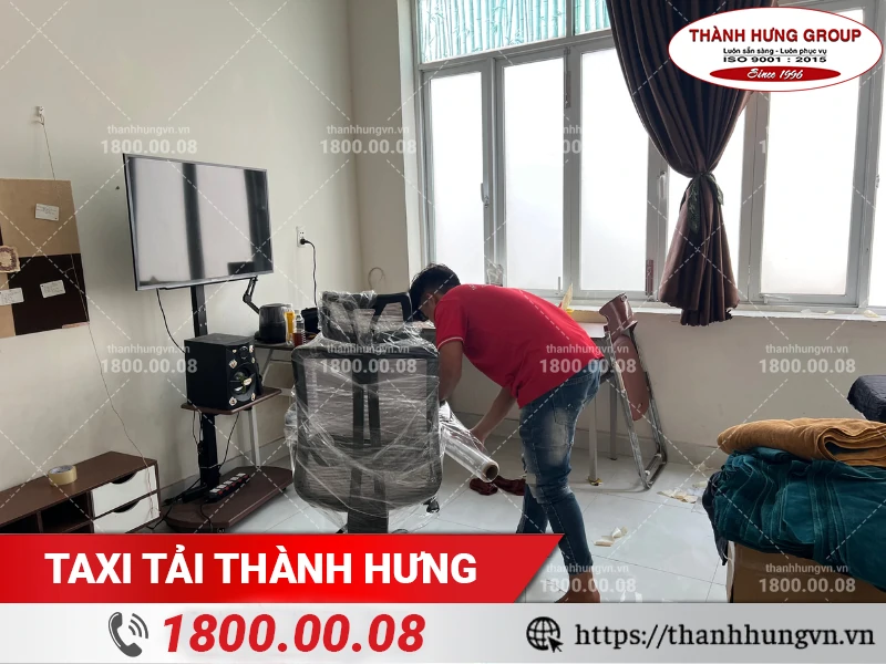 Nhân viên Thành Hưng đang bao bọc ghế tựa chắc chắn bằng màng PE