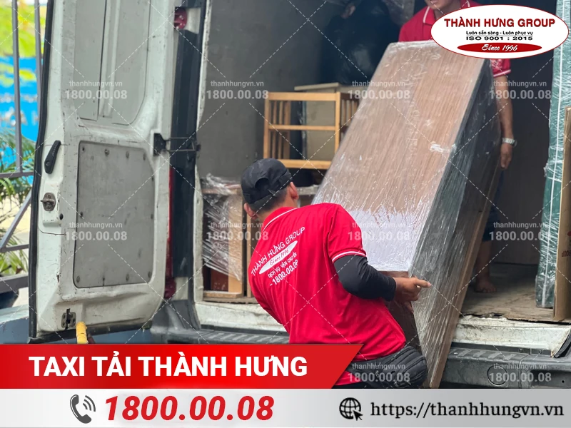 Nhân viên Thành Hưng khuân vác tủ gỗ lên xe vận chuyển
