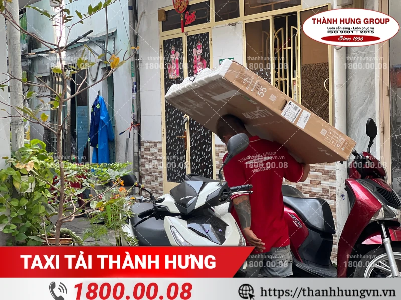 Nhân viên Thành Hưng đang vận chuyển tivi cỡ lớn ra xe tải