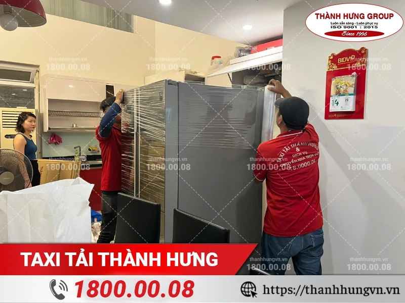 Nhân viên Thành Hưng đóng đang đóng gói tủ lạnh bằng màng PE
