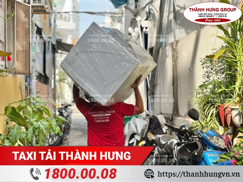 Nhân viên Thành Hưng khuân vác máy giặt từ hẻm ra xe vận chuyển
