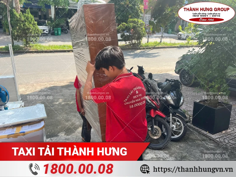 Nhân viên Thành Hưng vận chuyển tủ gỗ ra xe