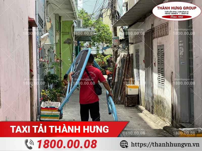 Các nhân viên Thành Hưng khuân vác từng bộ phận của giường ngủ vào nơi ở mới