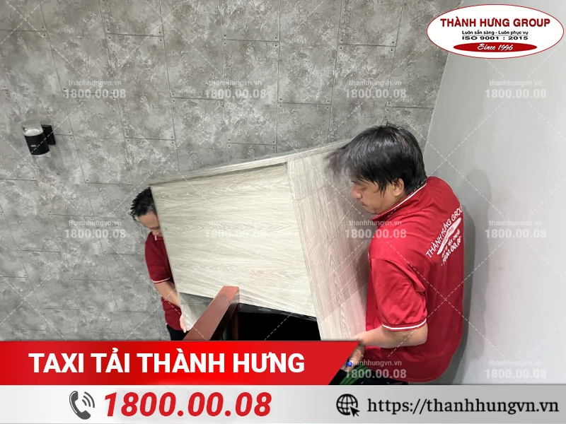Hai nhân viên Thành Hưng bốc xếp bàn xuống khu vực tập kết đồ