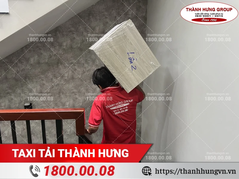 Nhân viên bốc xếp tủ gỗ xuống điểm tập kết đồ