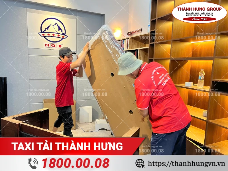 Nhân viên Thành Hưng đang bọc lót mặt bàn gỗ lớn