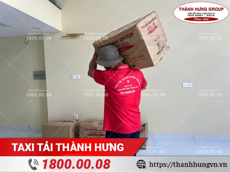 Nhân viên Thành Hưng khuân vác thùng đồ ra xe vận chuyển