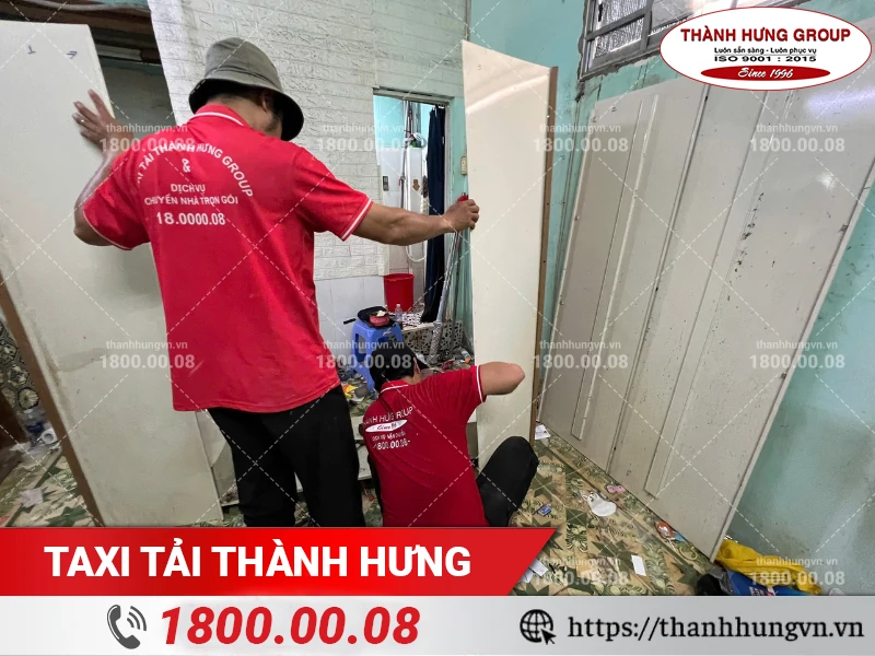 Nhân viên Thành Hưng tháo cánh tủ để di chuyển ra ngoài