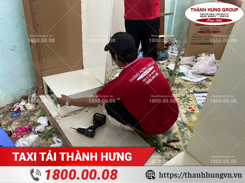 Nhân viên Thành Hưng tháo ngăn tủ bằng máy khoan trước khi vận chuyển