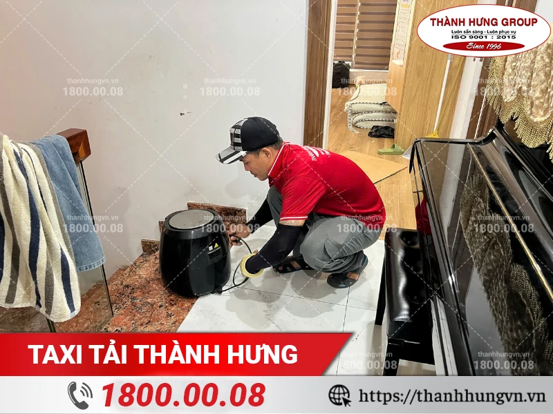 Nhân viên Thành Hưng cuộn băng keo bọc lót nồi chiên không dầu