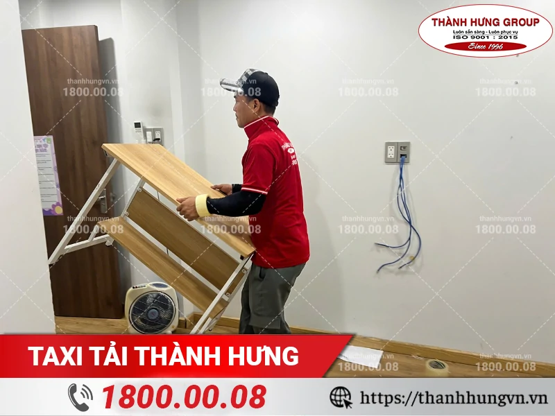 Nhân viên Thành Hưng khiêng bàn học gấp ra khỏi phòng