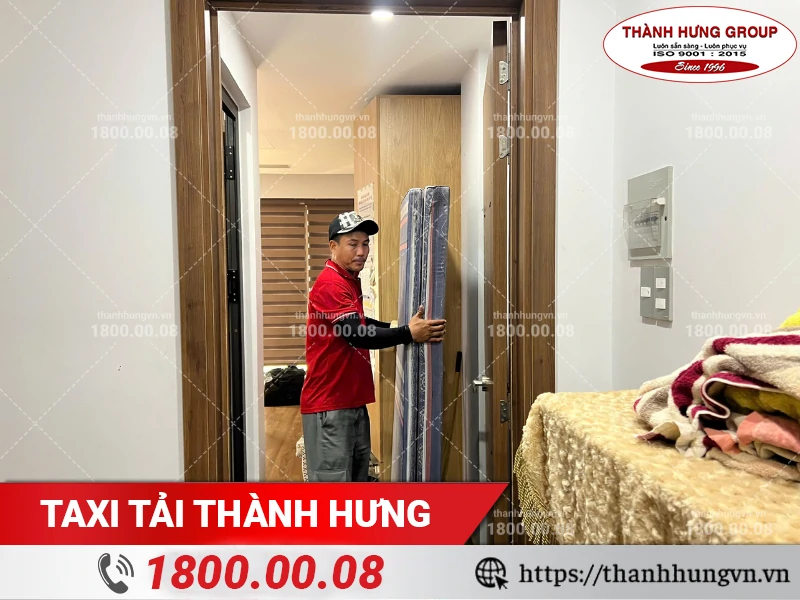 Nhân viên Thành Hưng khiêng nệm qua cửa phòng