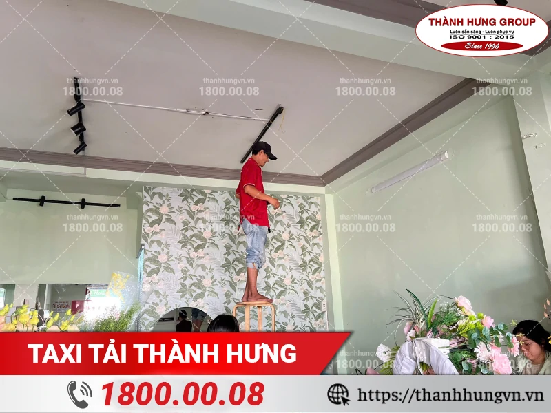 Nhân viên Thành Hưng tháo đèn trần tại cửa hàng hoa trước khi dọn