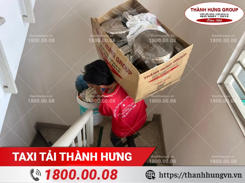 Nhân viên Thành Hưng bốc vác thùng đồ bếp xuống cầu thang