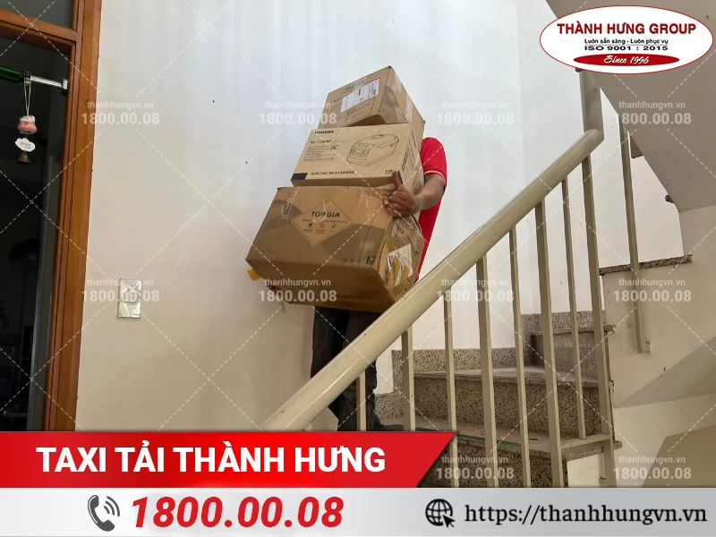 Nhân viên Thành Hưng khiêng nhiều hộp đồ điện tử xuống cầu thang
