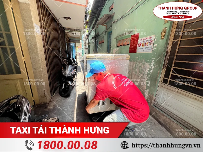 Nhân viên Thành Hưng di chuyển tủ đông từ hẻm ra xe