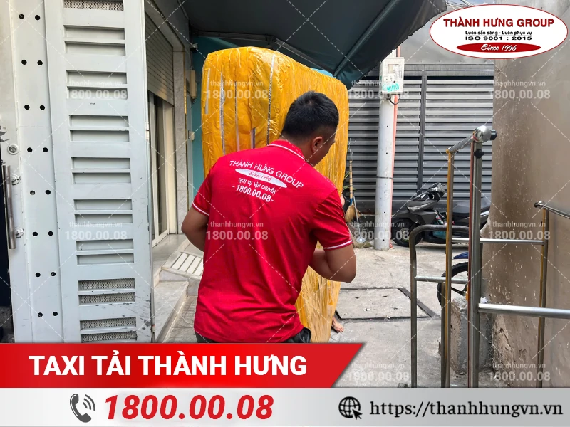 Nhân viên Thành Hưng khuân vác nệm qua lối đi hẹp