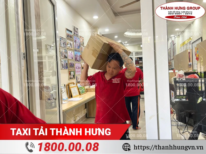 Nhân viên Thành Hưng bốc vác thùng đồ văn phòng qua hành lang