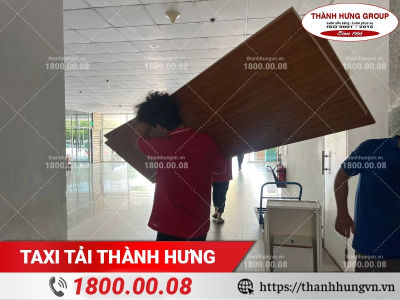 Nhân viên Thành Hưng bốc xếp mặt bàn gỗ xuống điểm tập kết