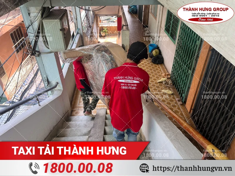Nhân viên Thành Hưng bốc xếp ghế sofa xuống cầu thang hẹp