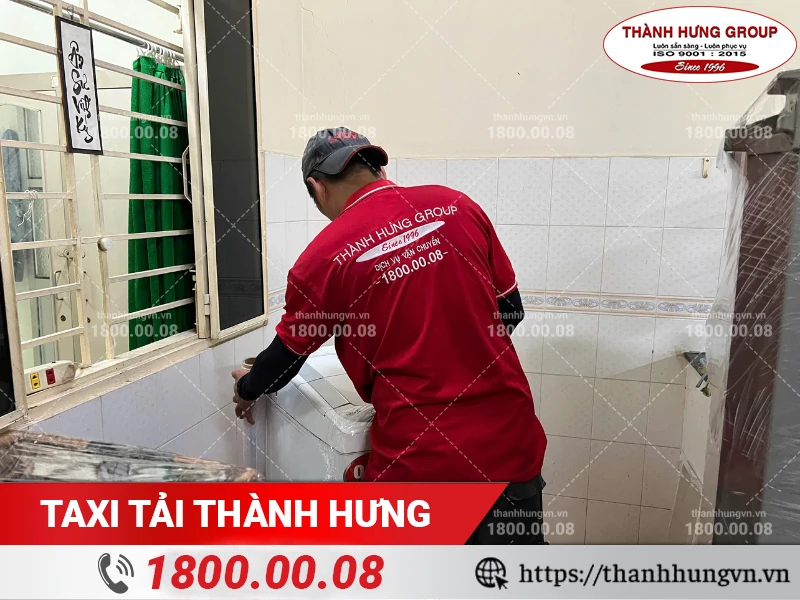 Nhân viên Thành Hưng dùng màng bọc PE bọc lót máy giặt