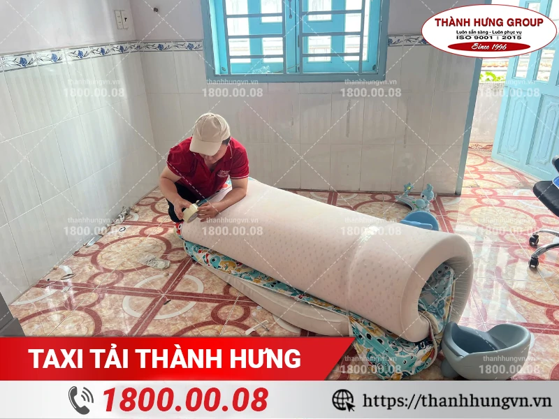 Nhân viên Thành Hưng cuộn nệm và cố định bằng băng keo