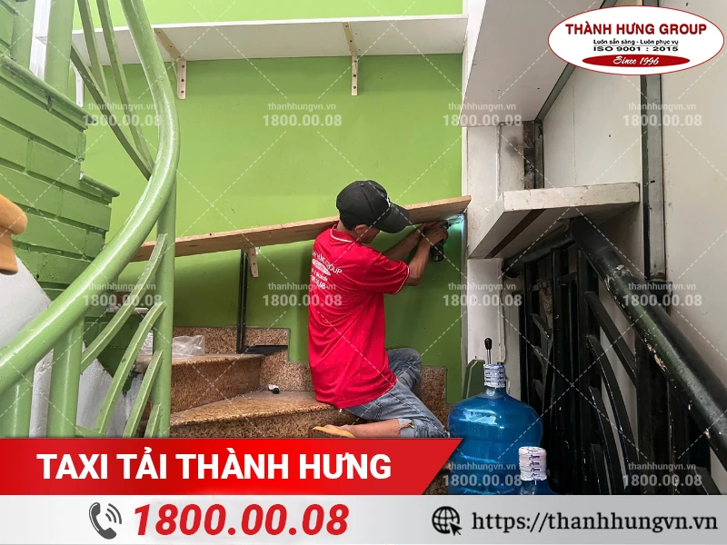 Nhân viên Thành Hưng tháo kệ gỗ gắn tường cầu thang