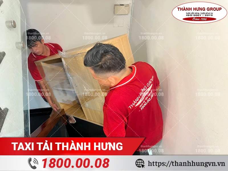 Nhân viên Thành Hưng bốc xếp tủ gỗ xuống cầu thang