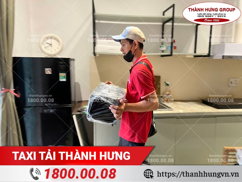 Nhân viên Thành Hưng mang lò vi sóng đã bọc lót ra khỏi bếp