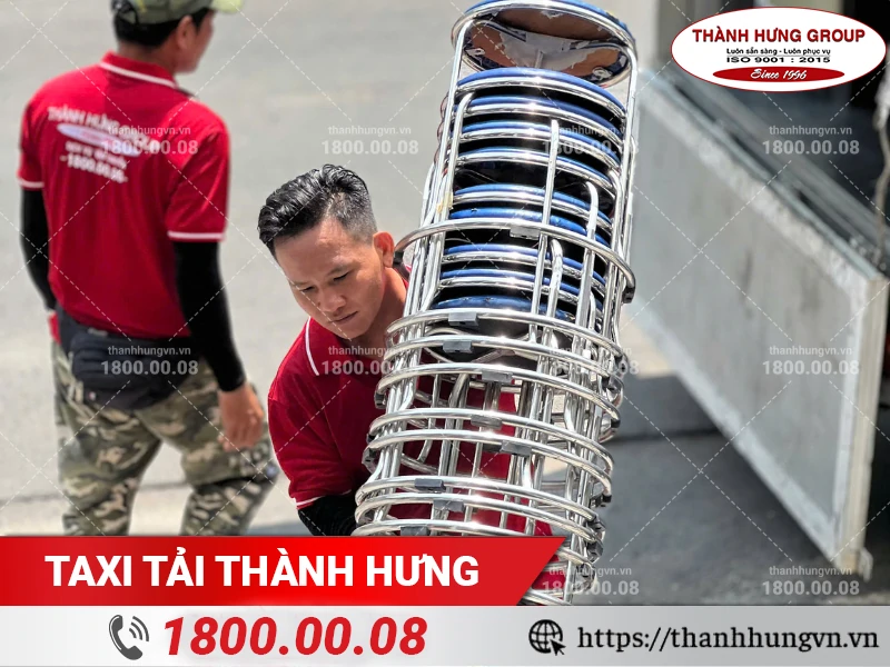 Nhân viên Thành Hưng chuyển chồng ghế inox vào địa điểm mới