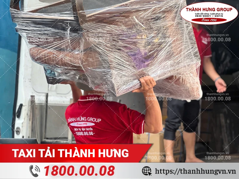 Nhân viên Thành Hưng khuân vác ghế sofa gỗ đã bọc lót ra xe