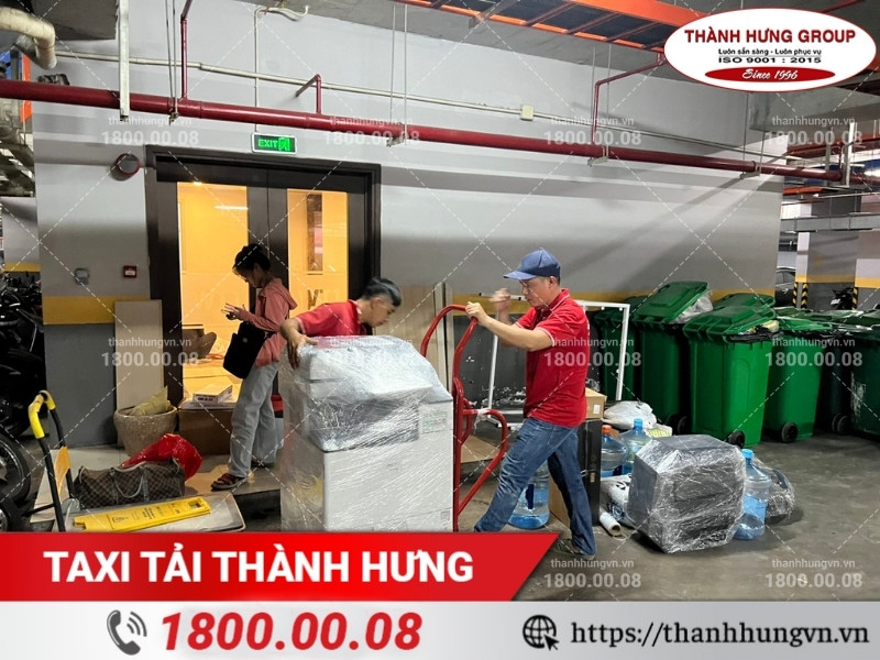 Nhân sự Thành Hưng sử dụng xe đẩy để vận chuyển máy photocopy.
