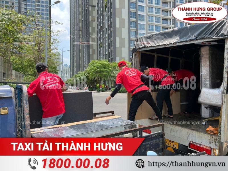 Nhân viên bốc xếp đồ đạc cẩn thận lên xe tải có thùng kín.