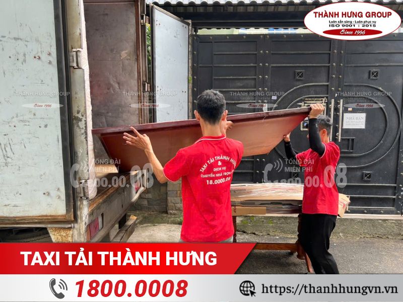 Nhân viên Taxi Tải Thành Hưng cẩn thận vận chuyển đồ dạc lên xe tải