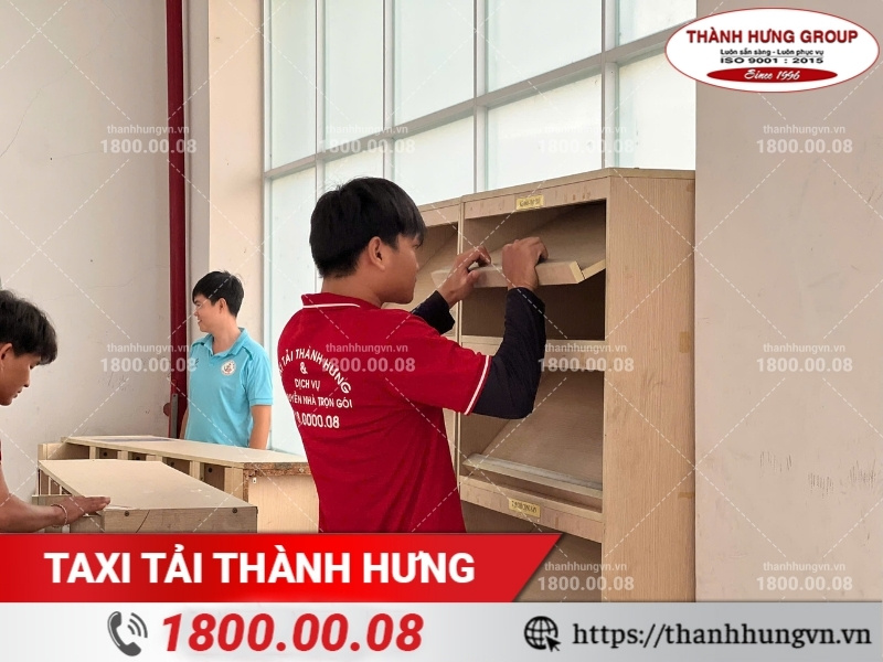 Nhân viên Thành Hưng tháo dỡ kệ sách bằng gỗ